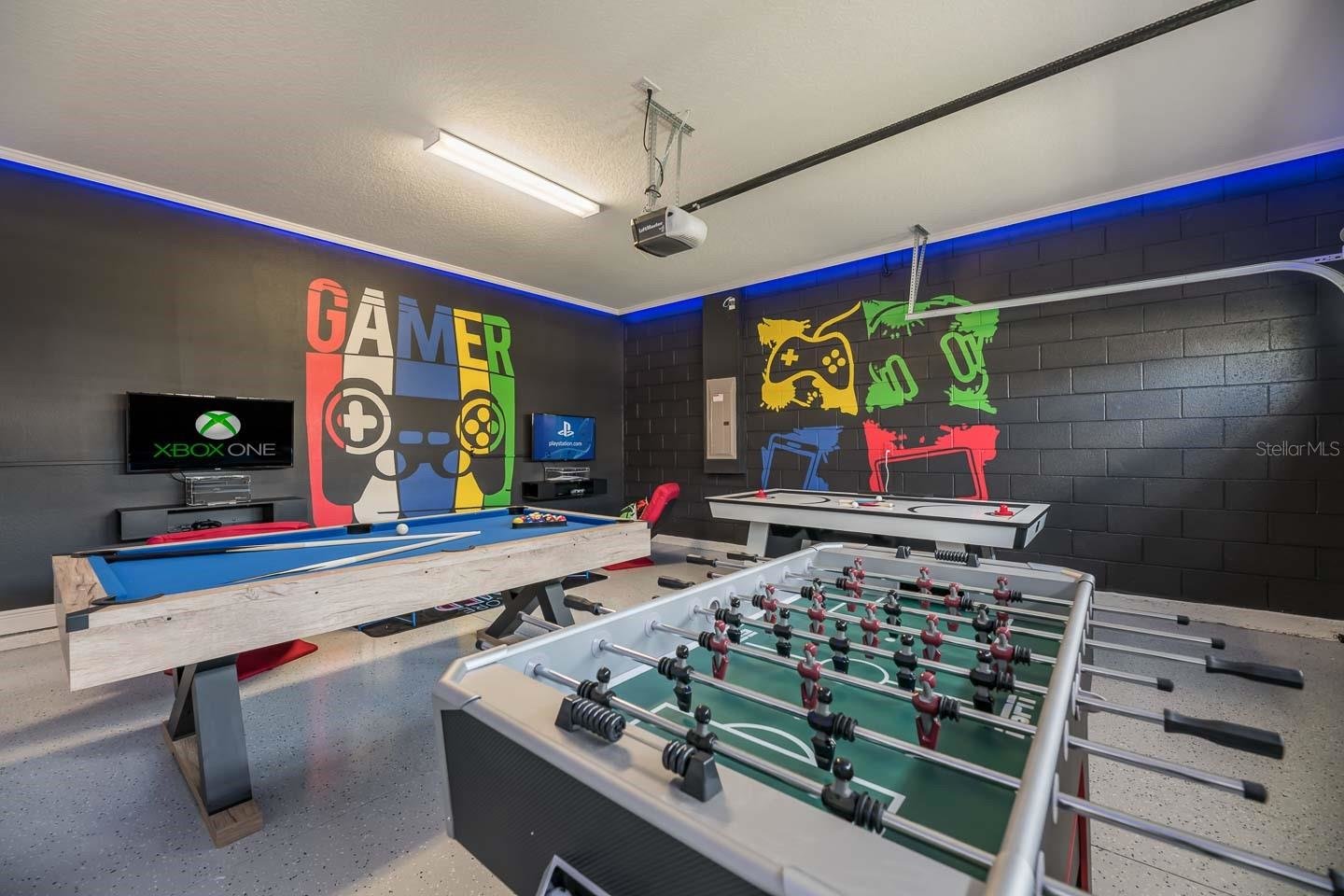garage converted game room with black walls and spray paint designs